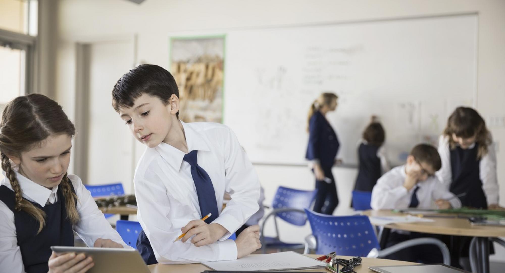 Two schoolchildren using an iPad