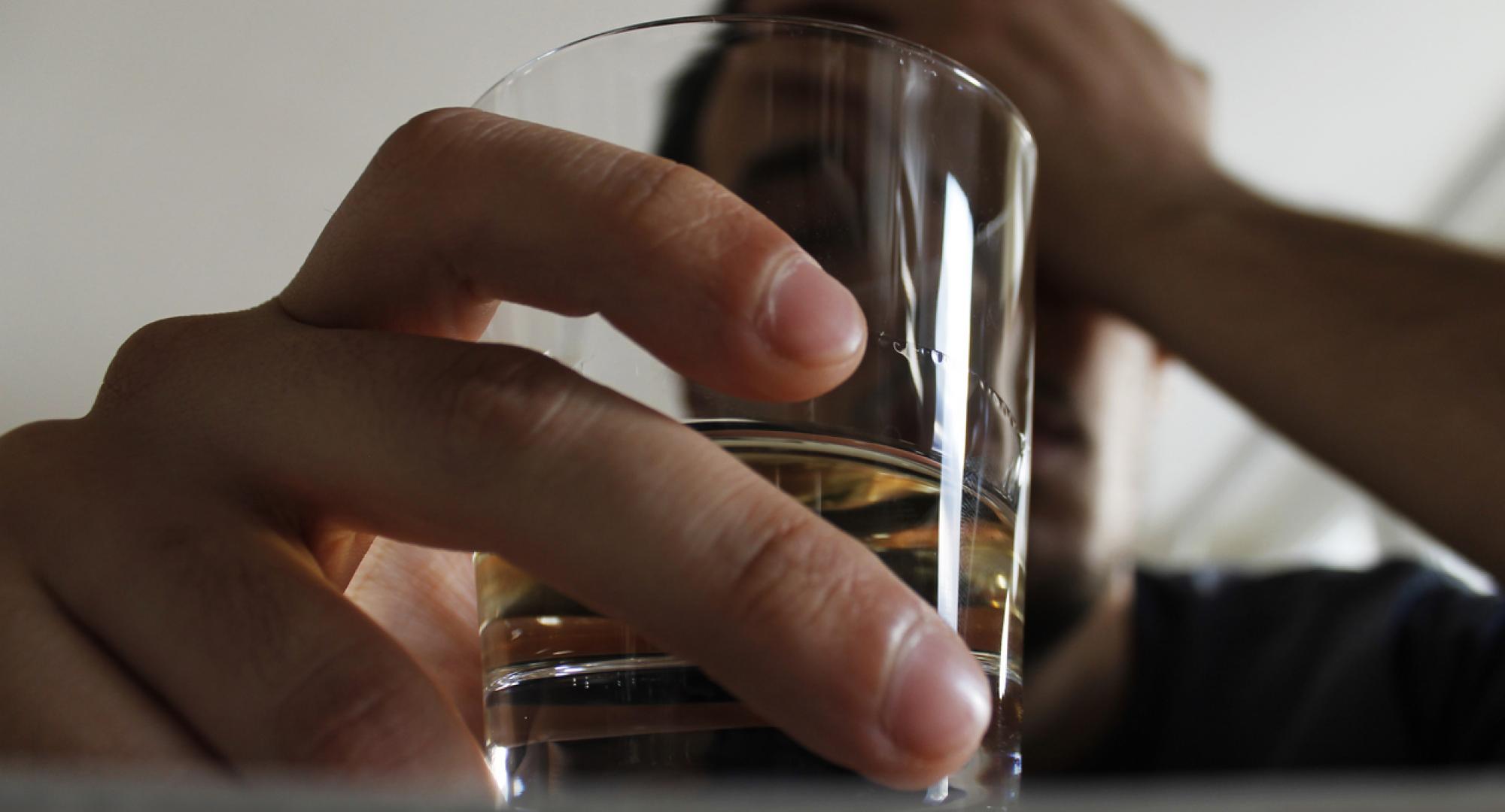 Man holding class of alcohol