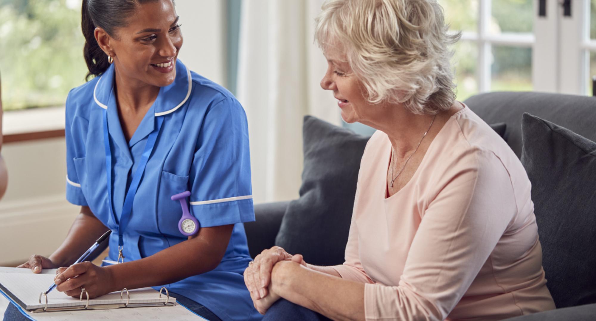 Social care worker sat with an older woman