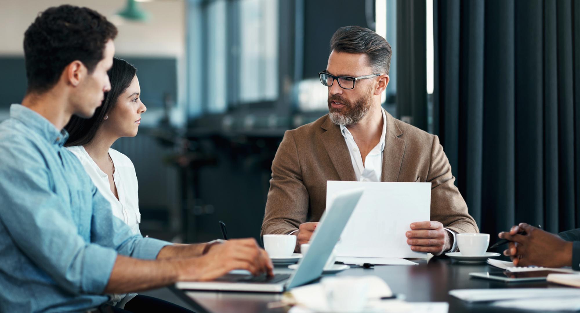 Man with beard talking with colleagues