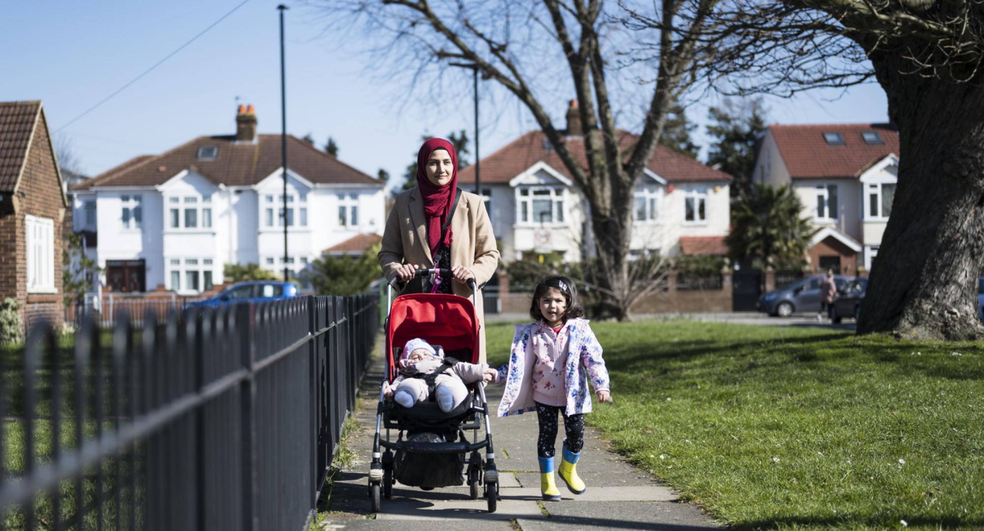 Woman and daughter walking through Hounslow on a sunny day