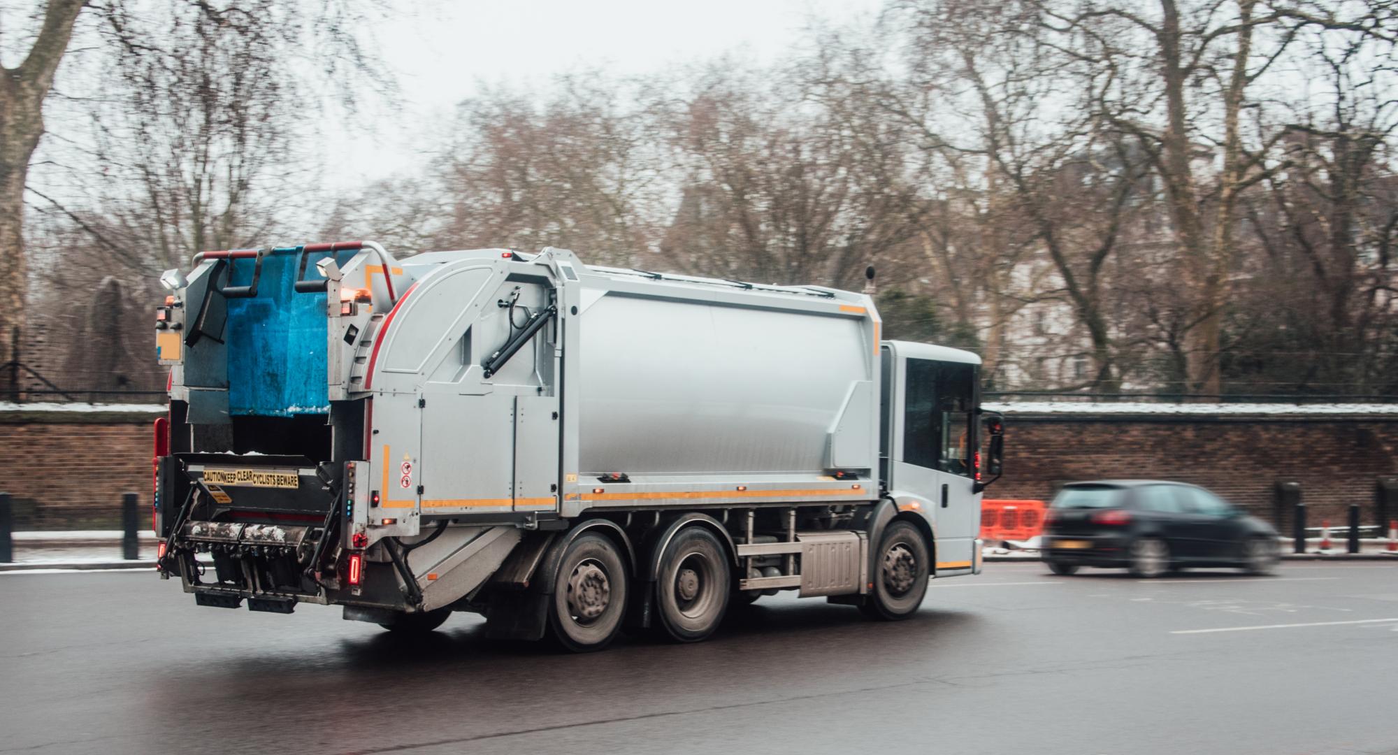 A garbage truck in the middle of a city