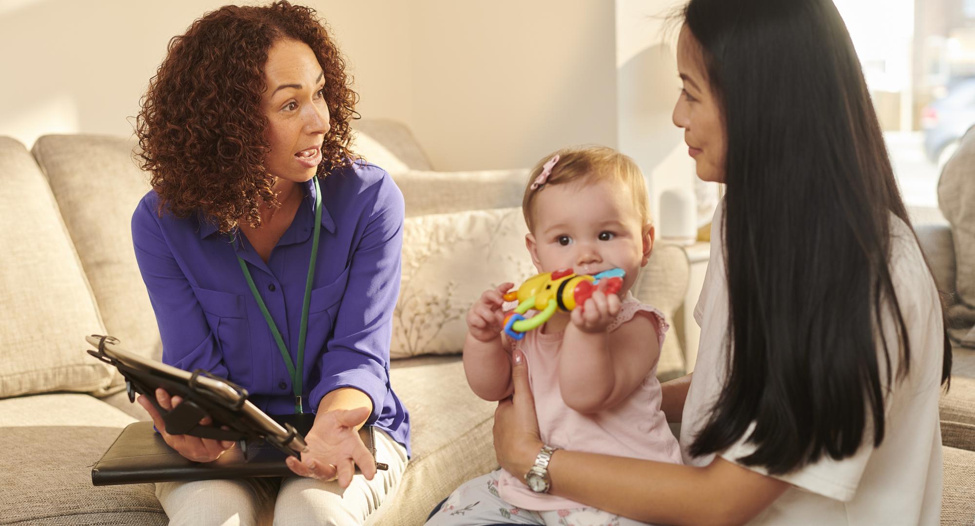 Official chatting to young mother