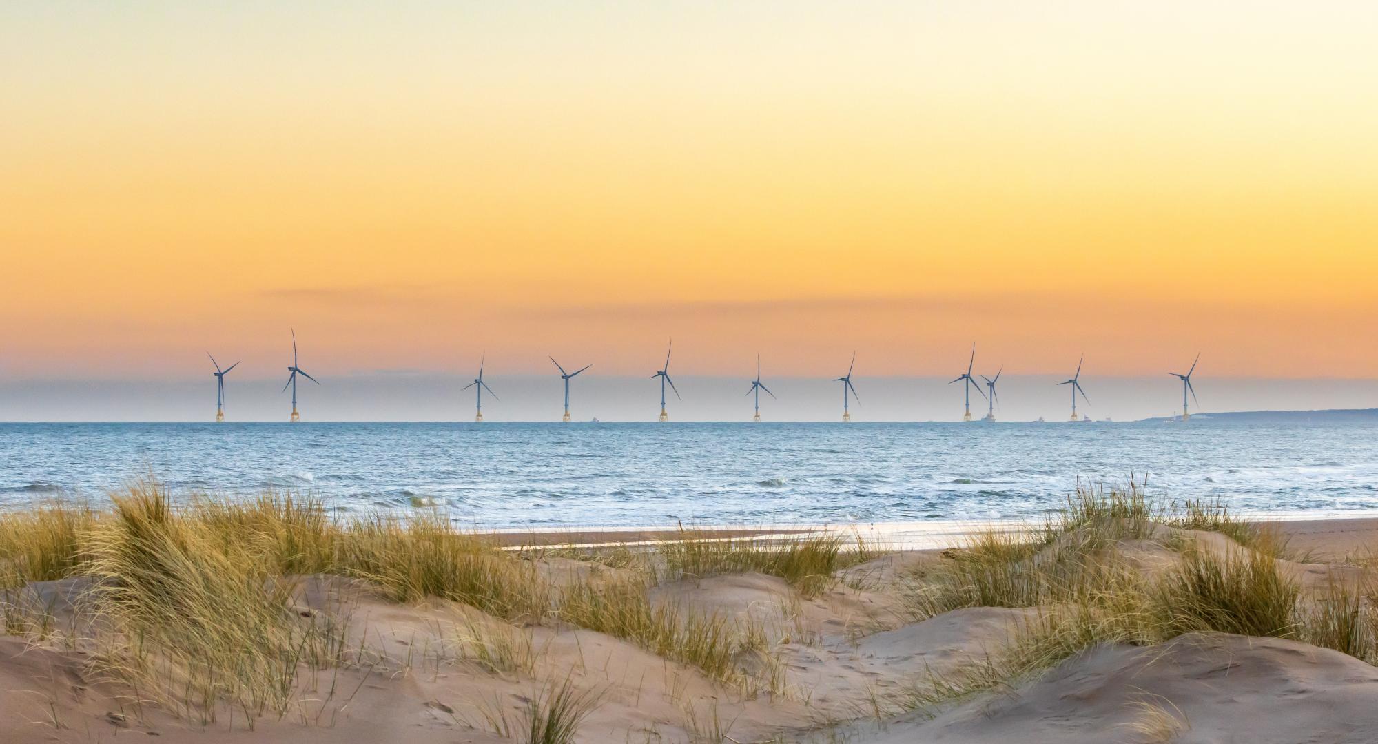 Offshore windfarm with sand dunes in the foreground