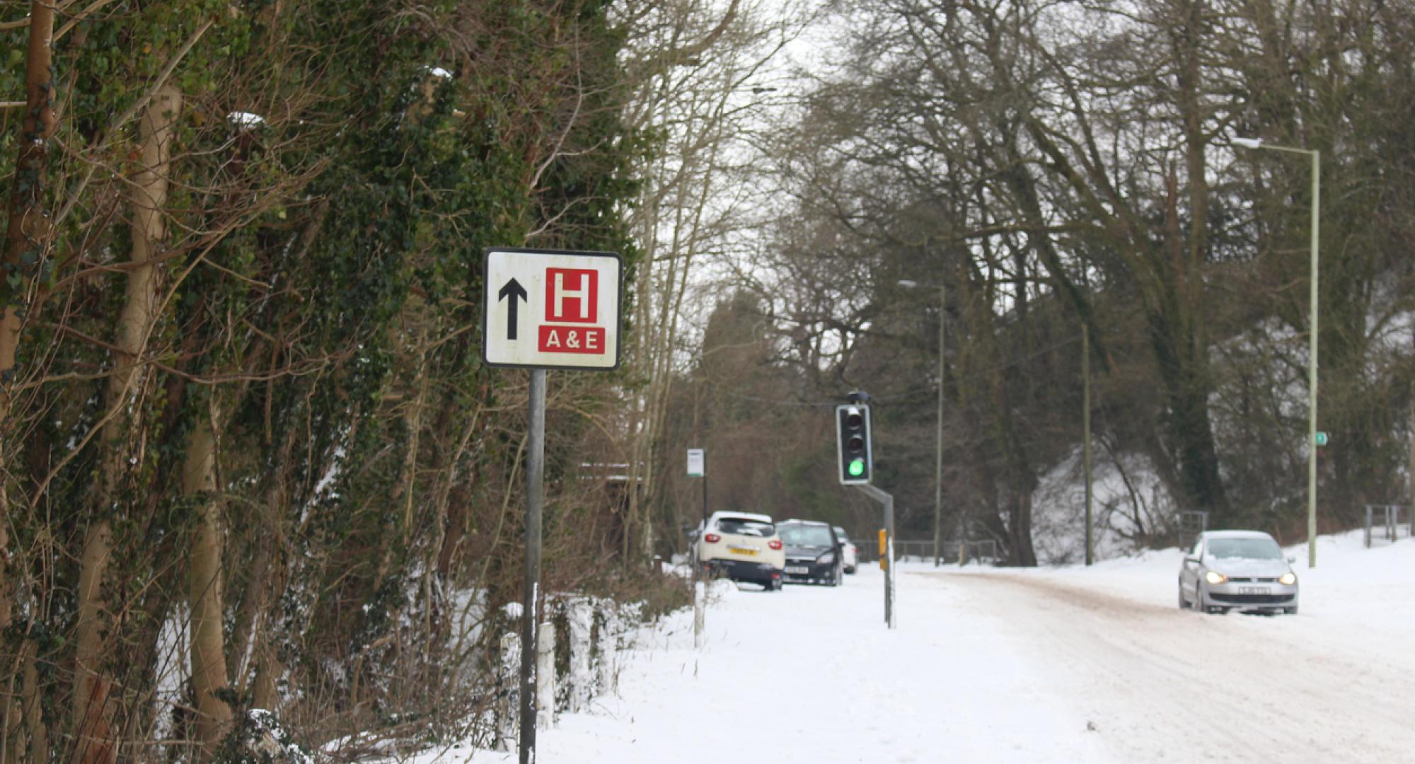 A sign for a hospital on a snowy road