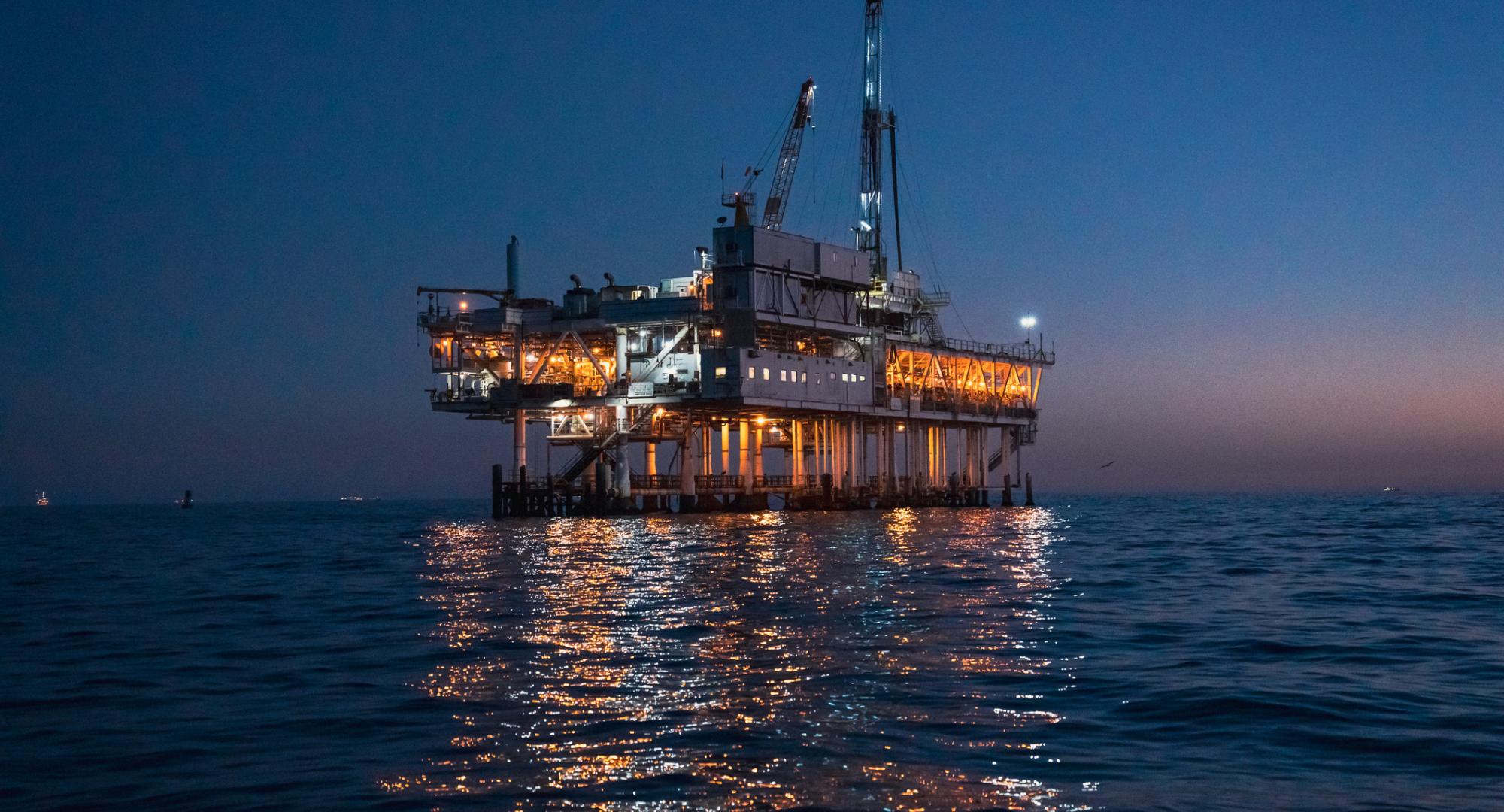 Night Time Offshore Oil Rig Drilling and Fracking Operation, Brightly Lit, on Calm Seas, Oil Platform