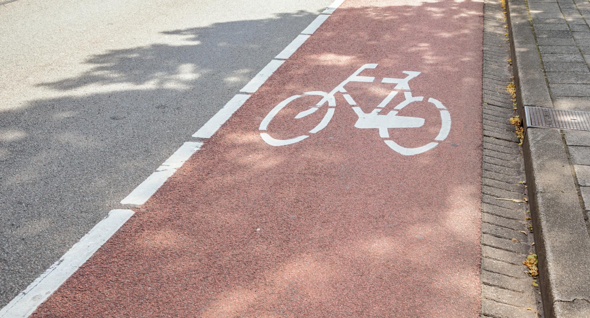 Red bicycle lane along a street in a city centre