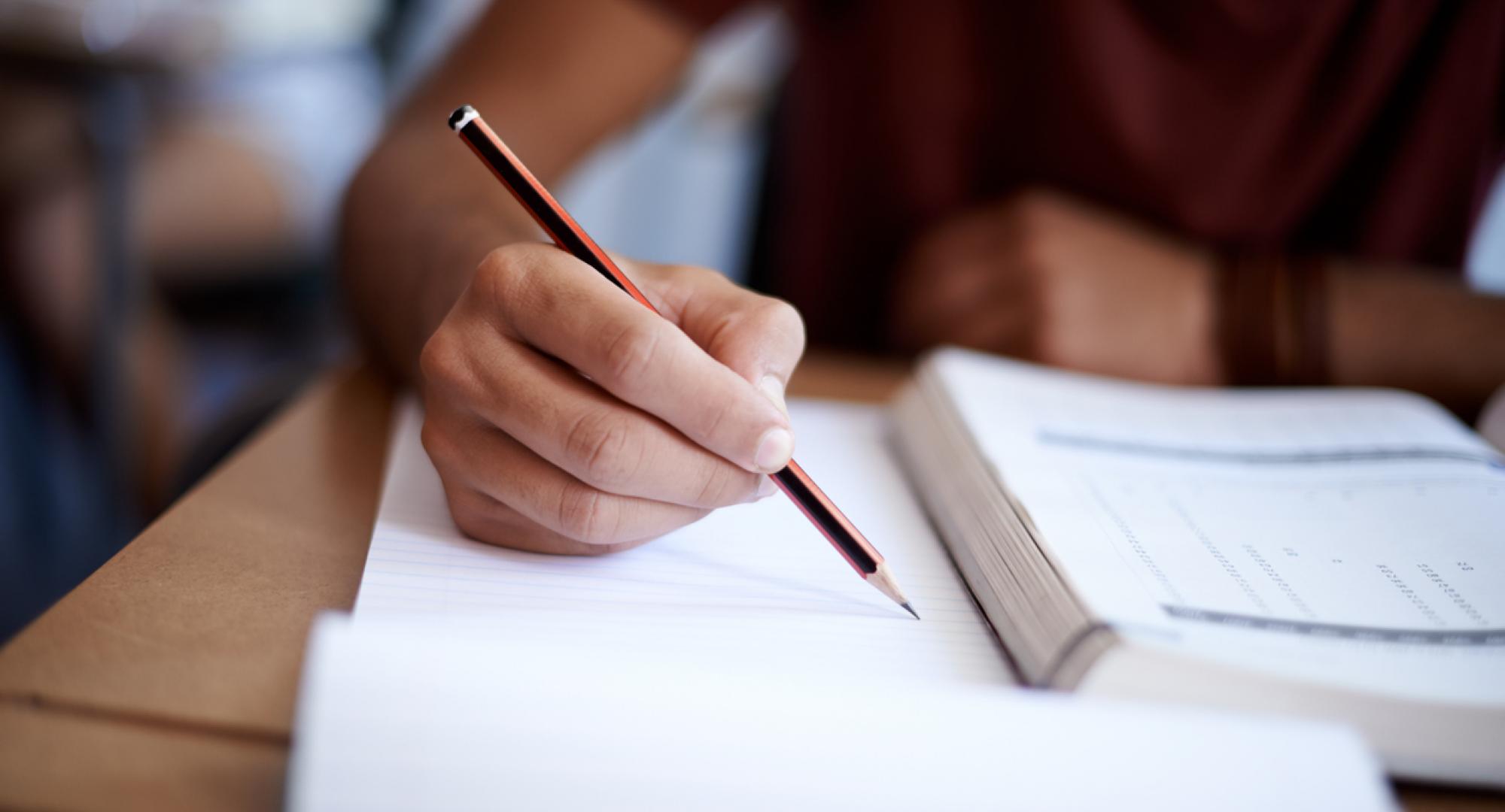 Closeup shot of an ex-offender writing on a note pad