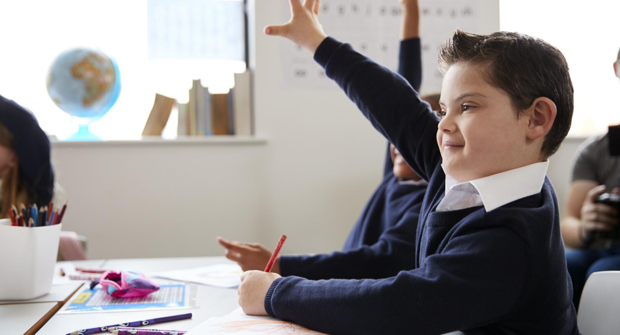 Schoolboy with Down syndrome sitting at a desk