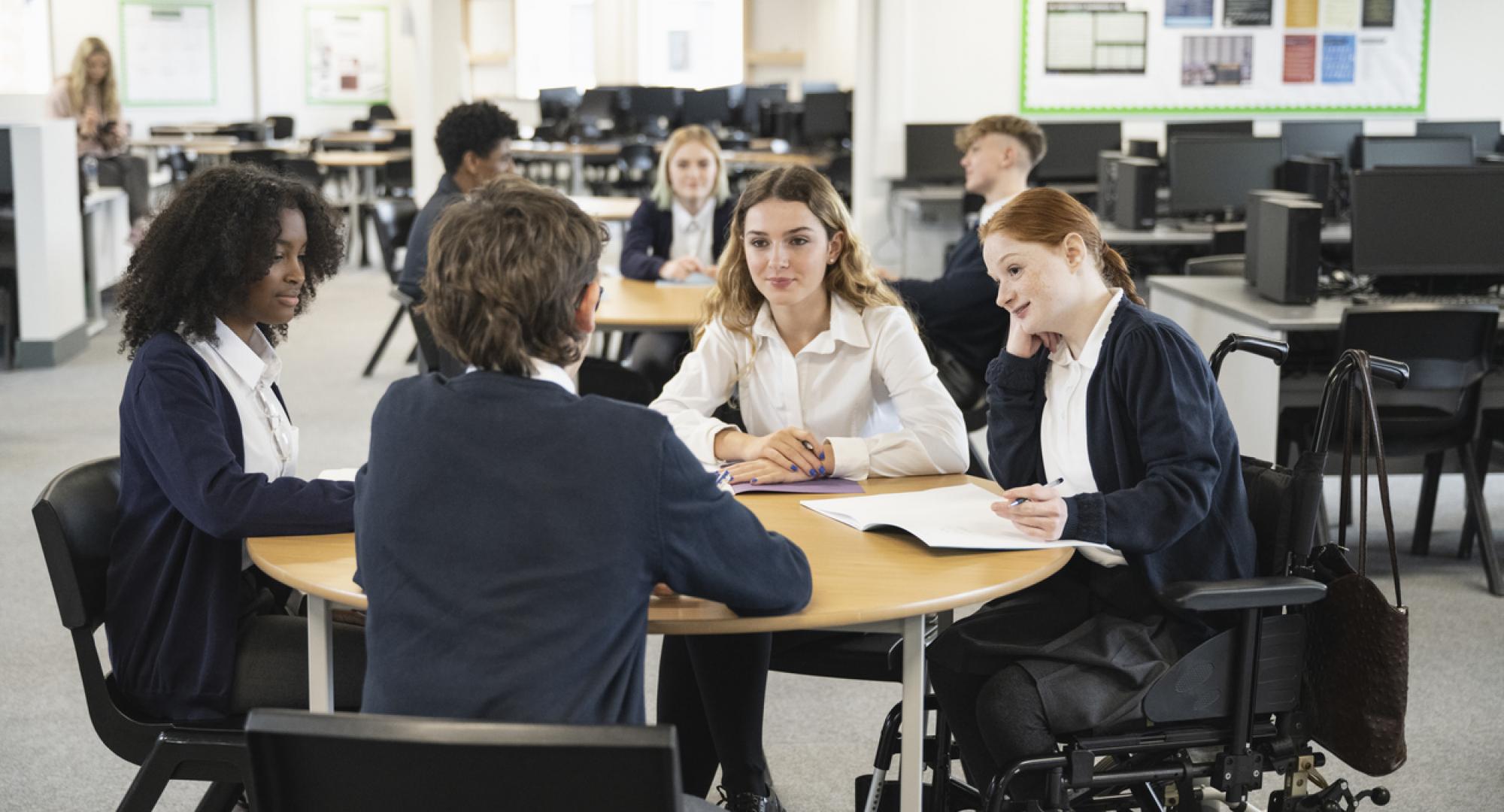 Teenage students interacting in collaborative workspace