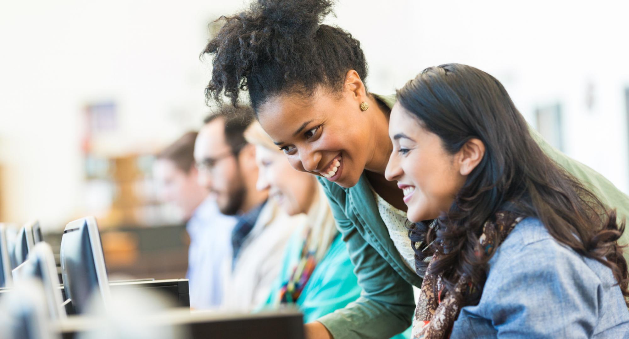 Diverse mid adult students using computers during class in college