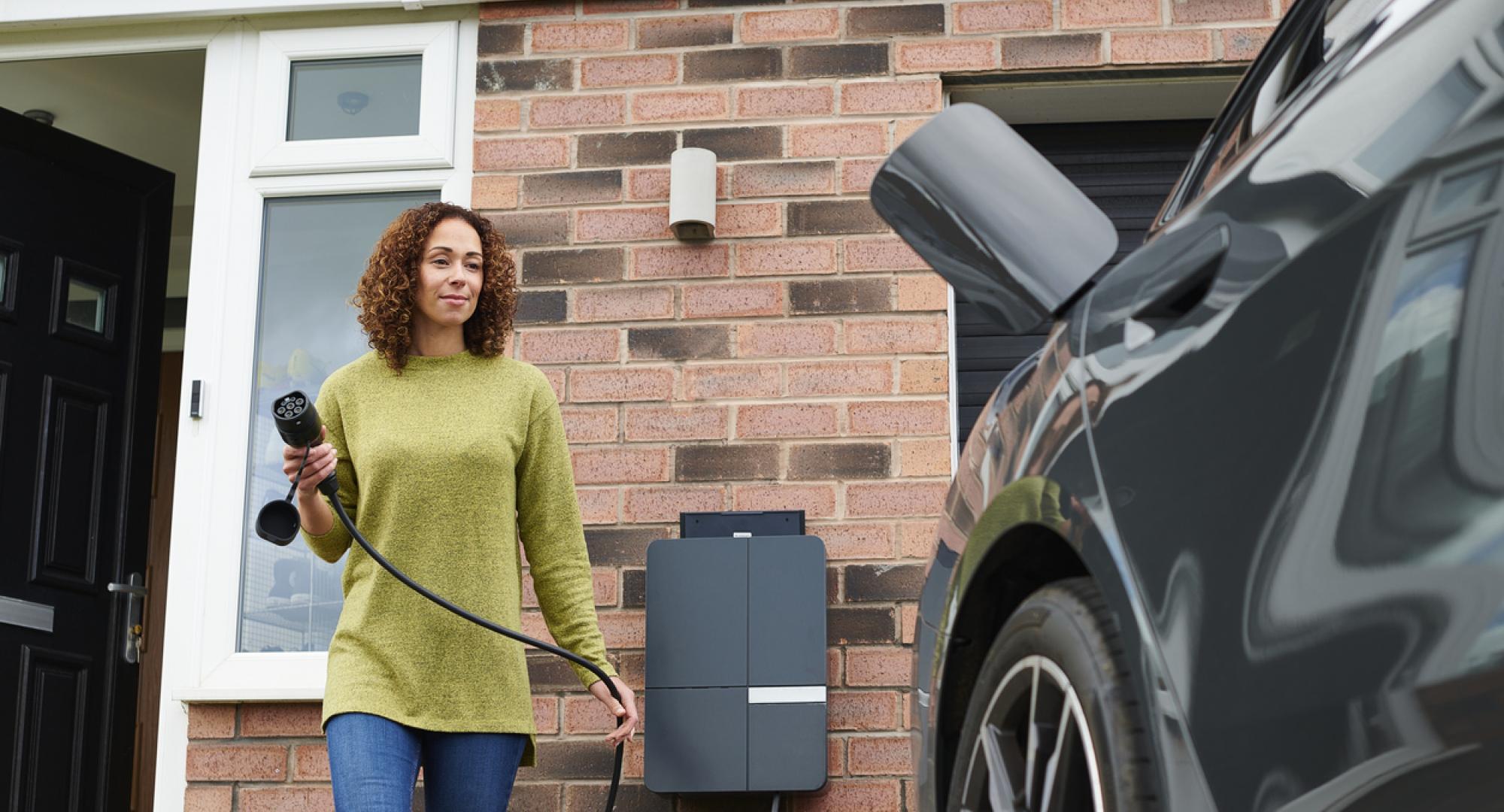 homeowner charging electric car on driveway