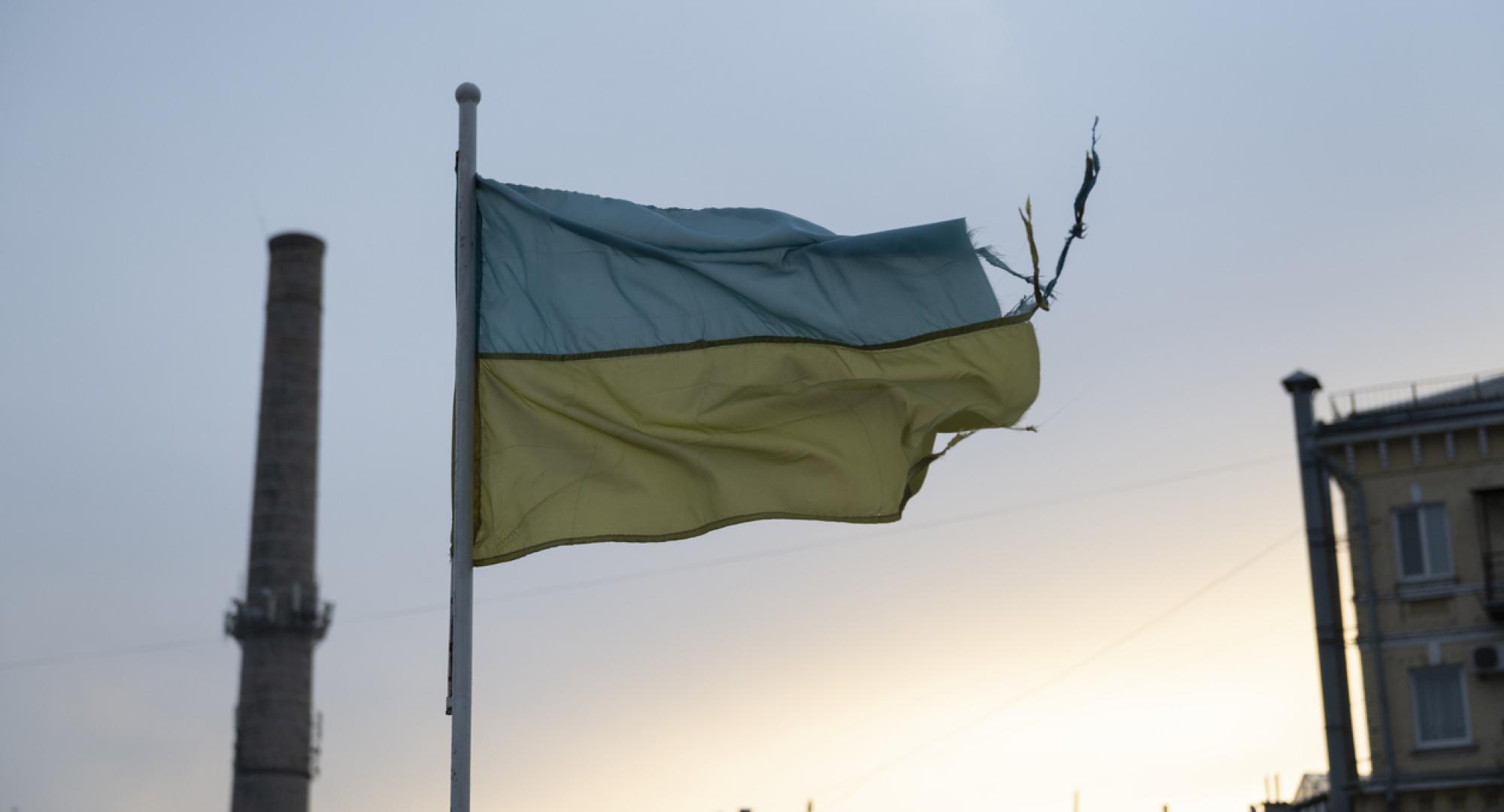 weathered Ukrainian flag flies in the Podil district of Kyiv, Ukraine