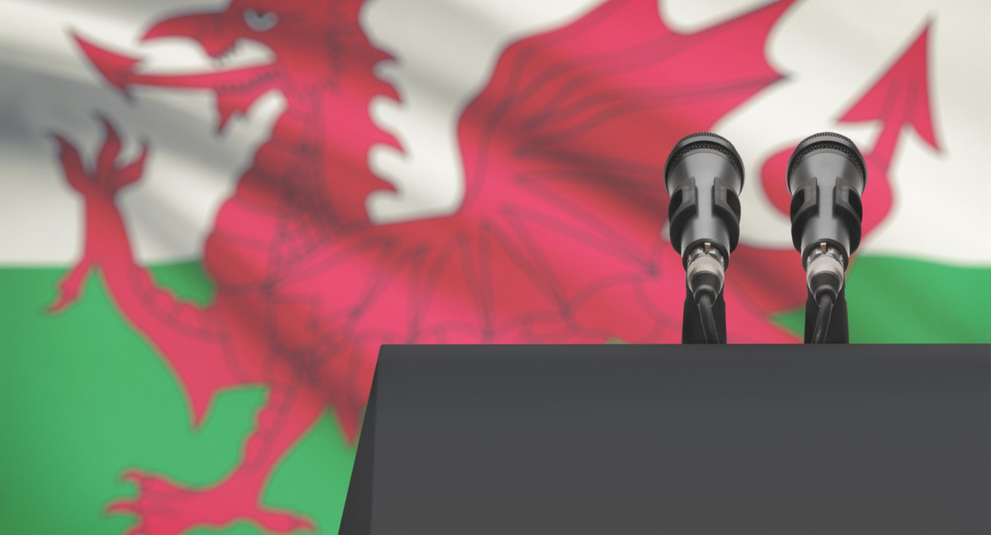 Pulpit and two microphones with a flag on background - Wales