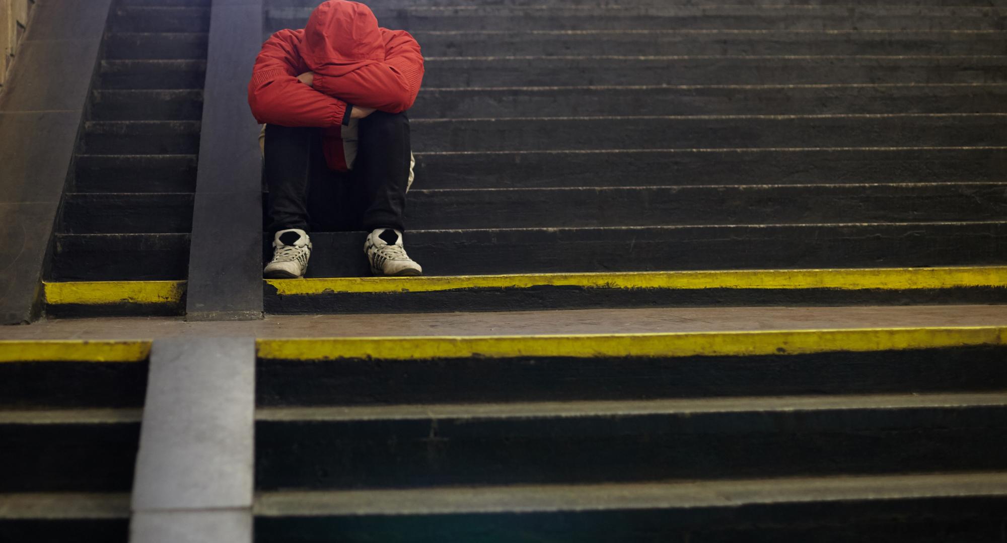 young homeless man sleeping on the street