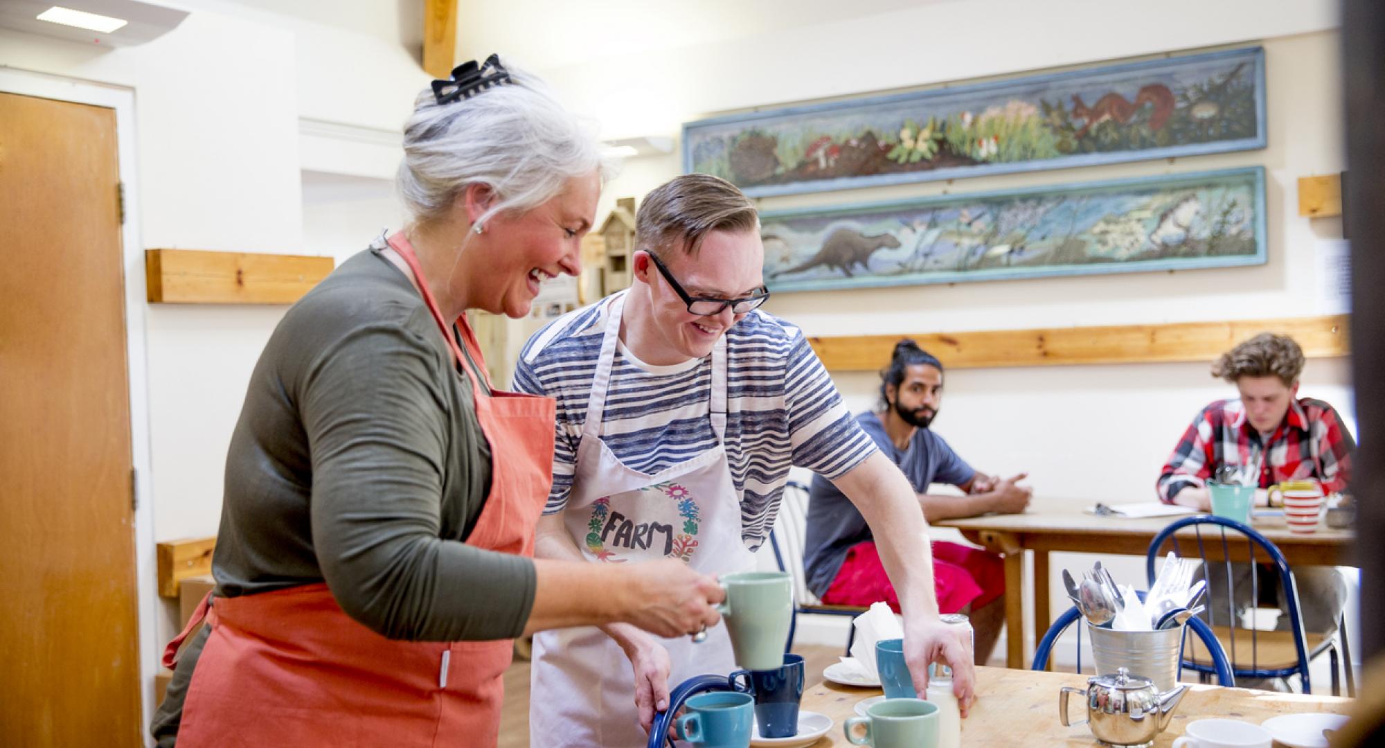 A man and woman prepare hot drinks in the local farm cafe.