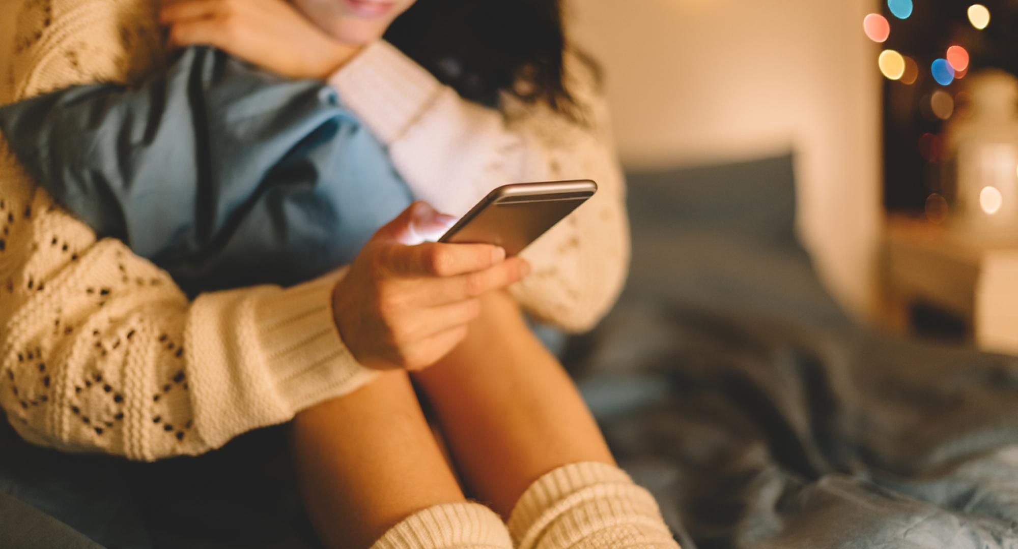 Girl texting on smartphone at home