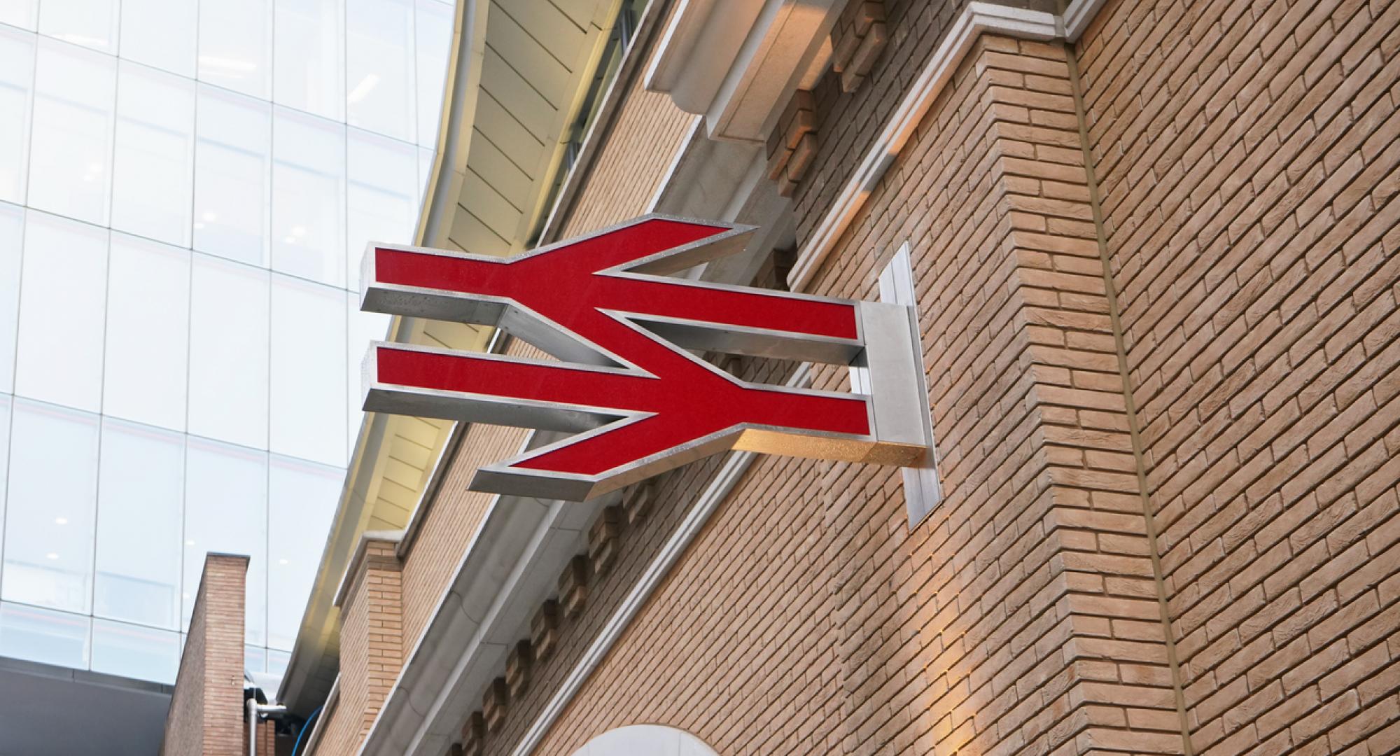 Red British railway logo on orange brick wall