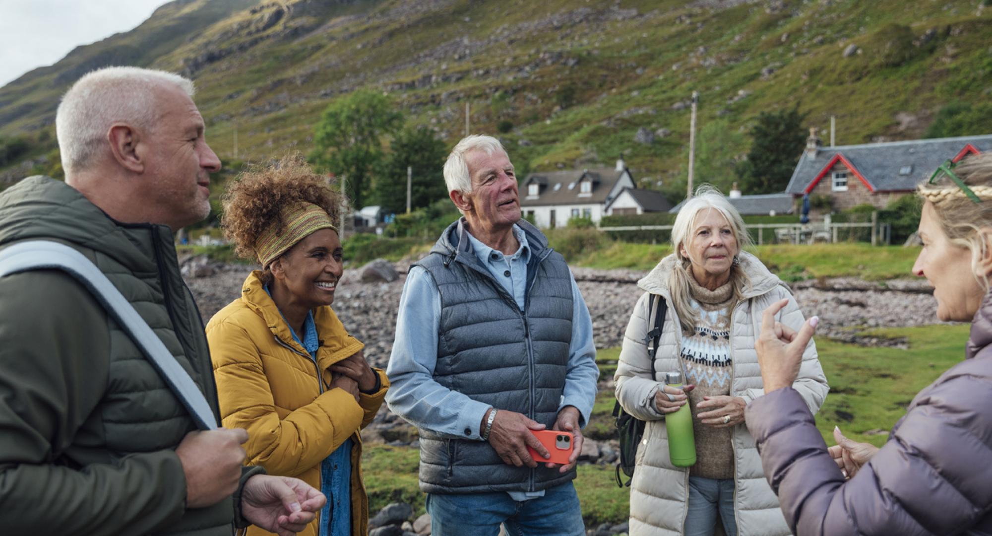 a small group of adults standing on the shore of a sea loch in Torridon, Scotland