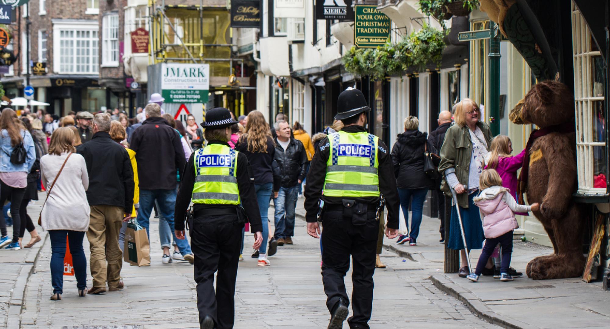 A pair of British policemen and woman on patrol on the streets of York