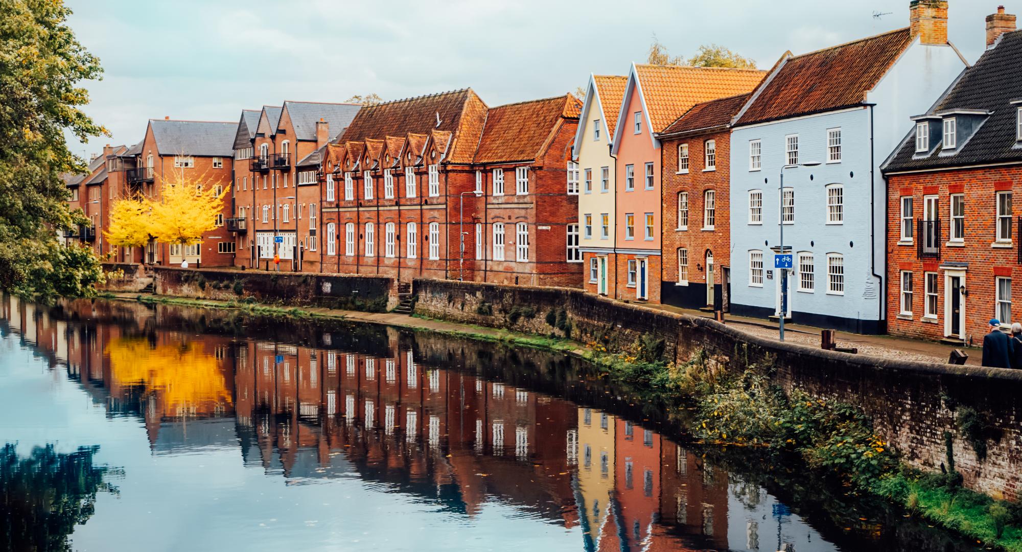 Street view with colorful brick houses near river in the english town of Norwich, England