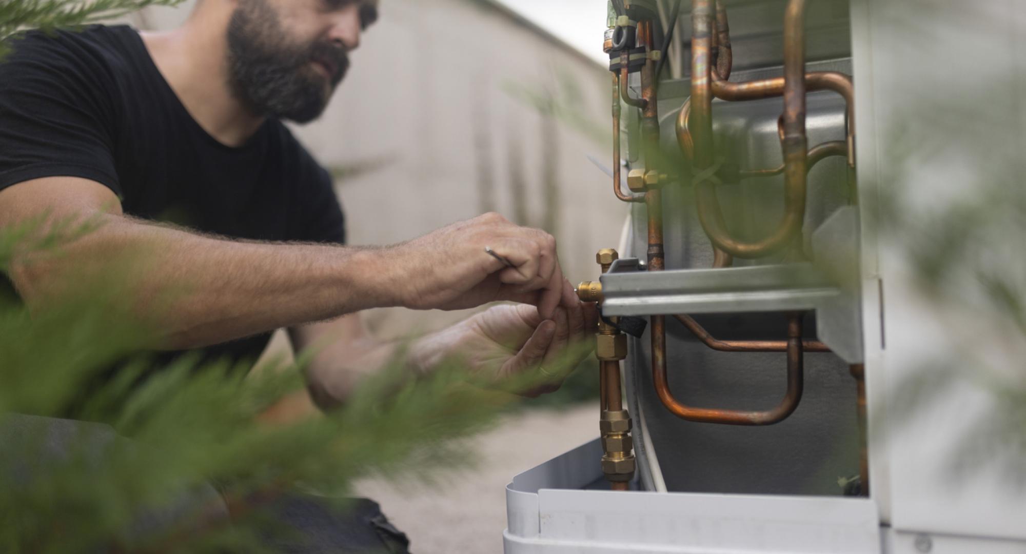 Technician installing a heat pump in the yard