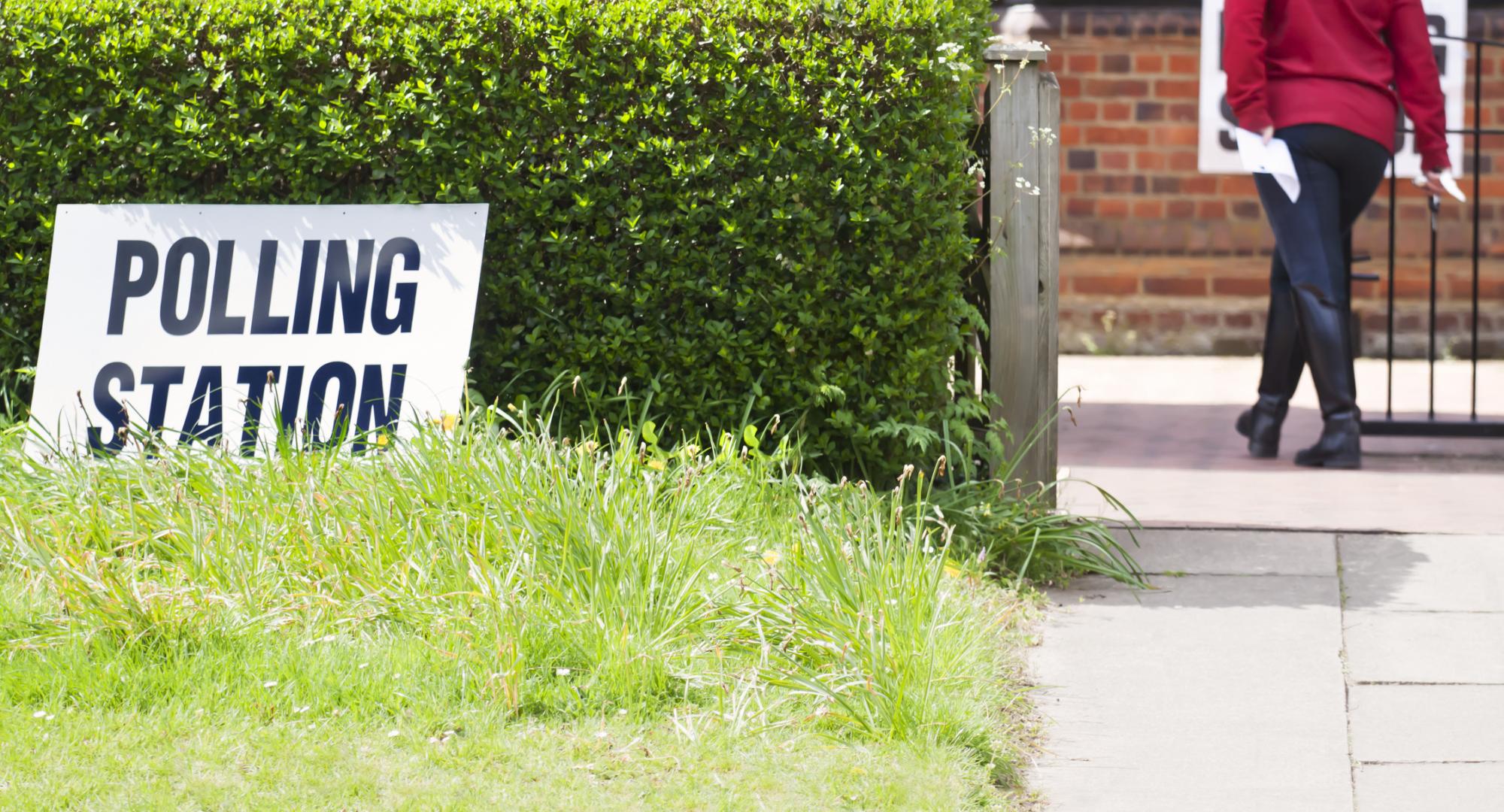 a woman taking her polling card to cast her vote