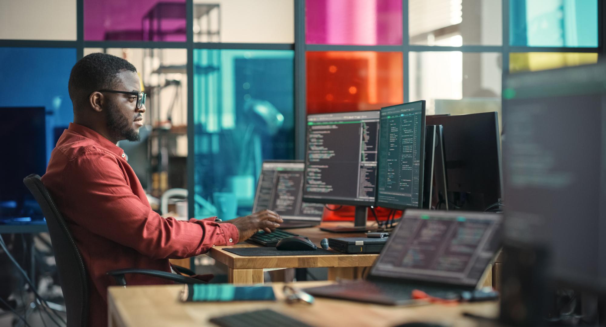 Man writing lines of code on a computer