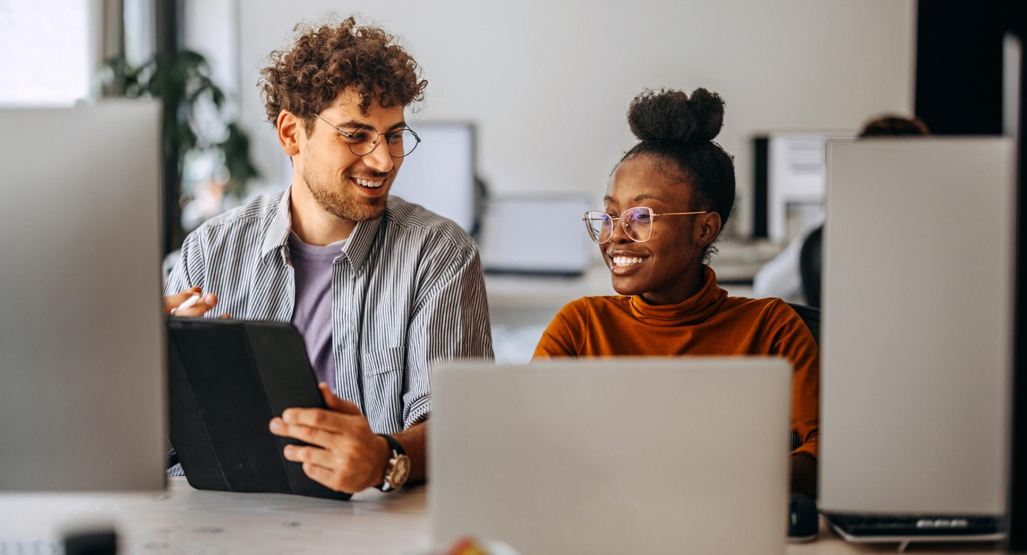 Two young colleagues working together at modern office