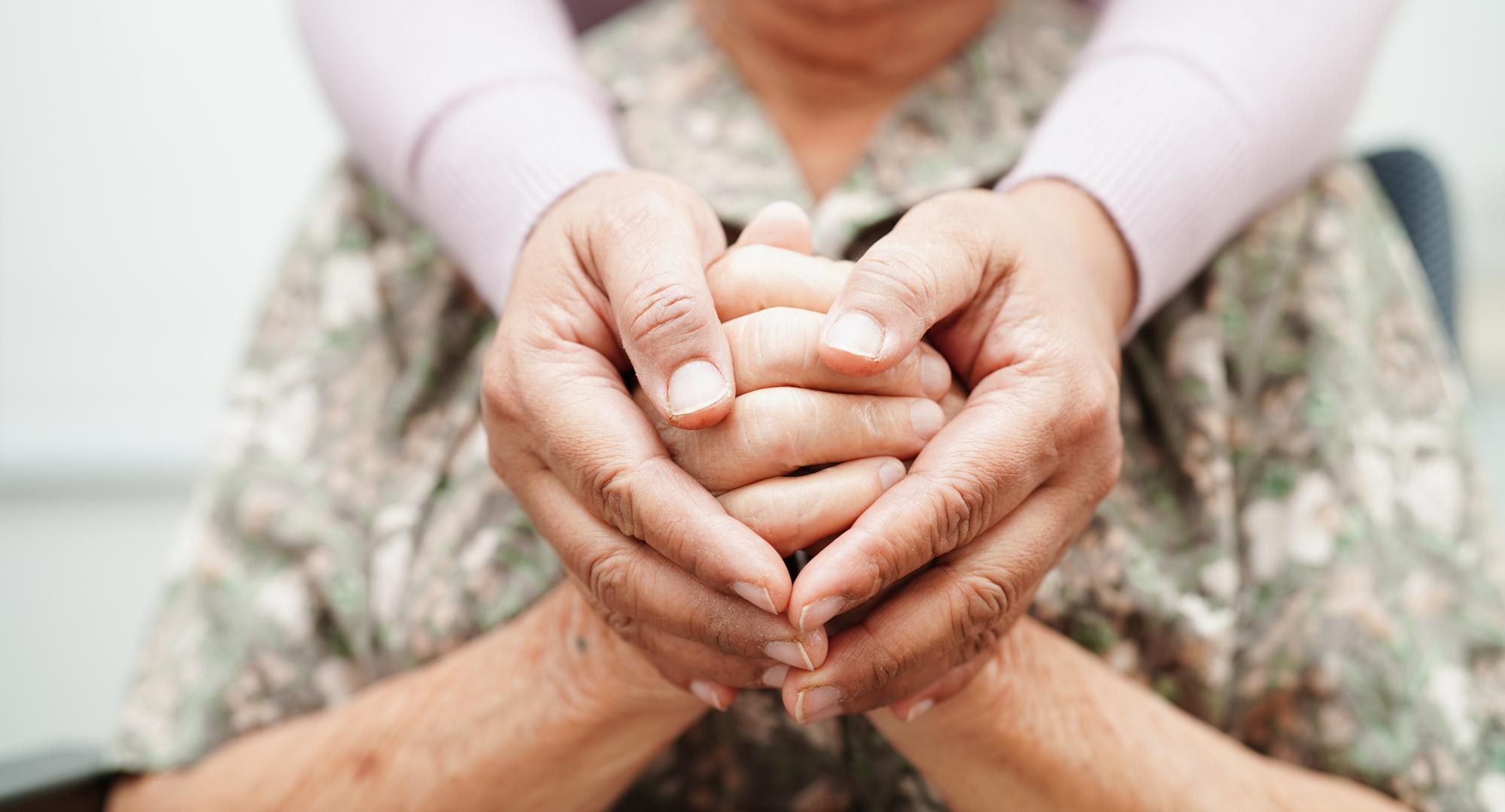 Carer holding hands with patient