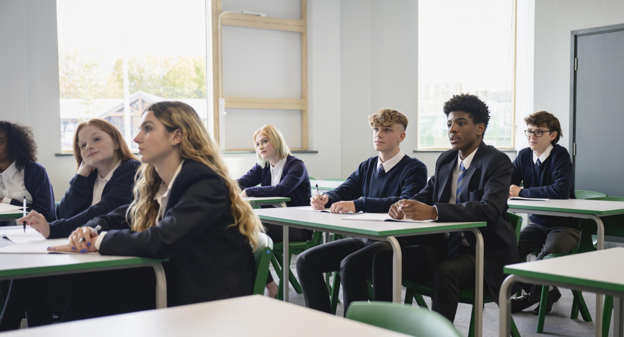Male and female teenagers in secondary classroom