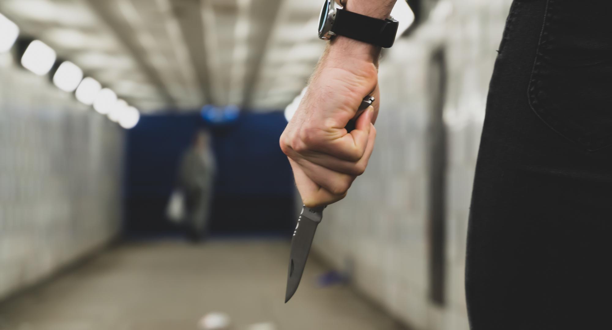 Person in an underpass holding a knife