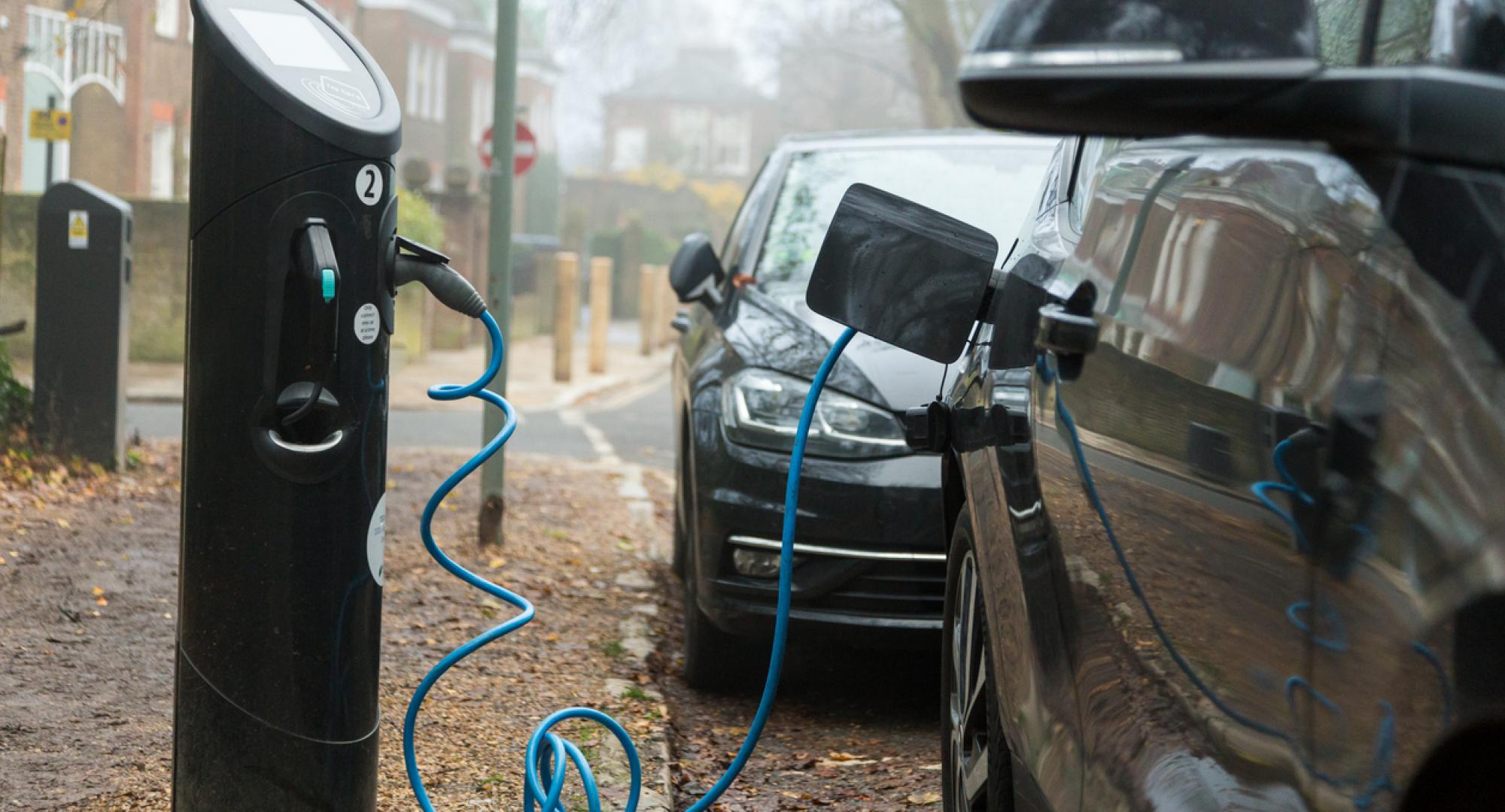 A modern electric car being charged at a charging point
