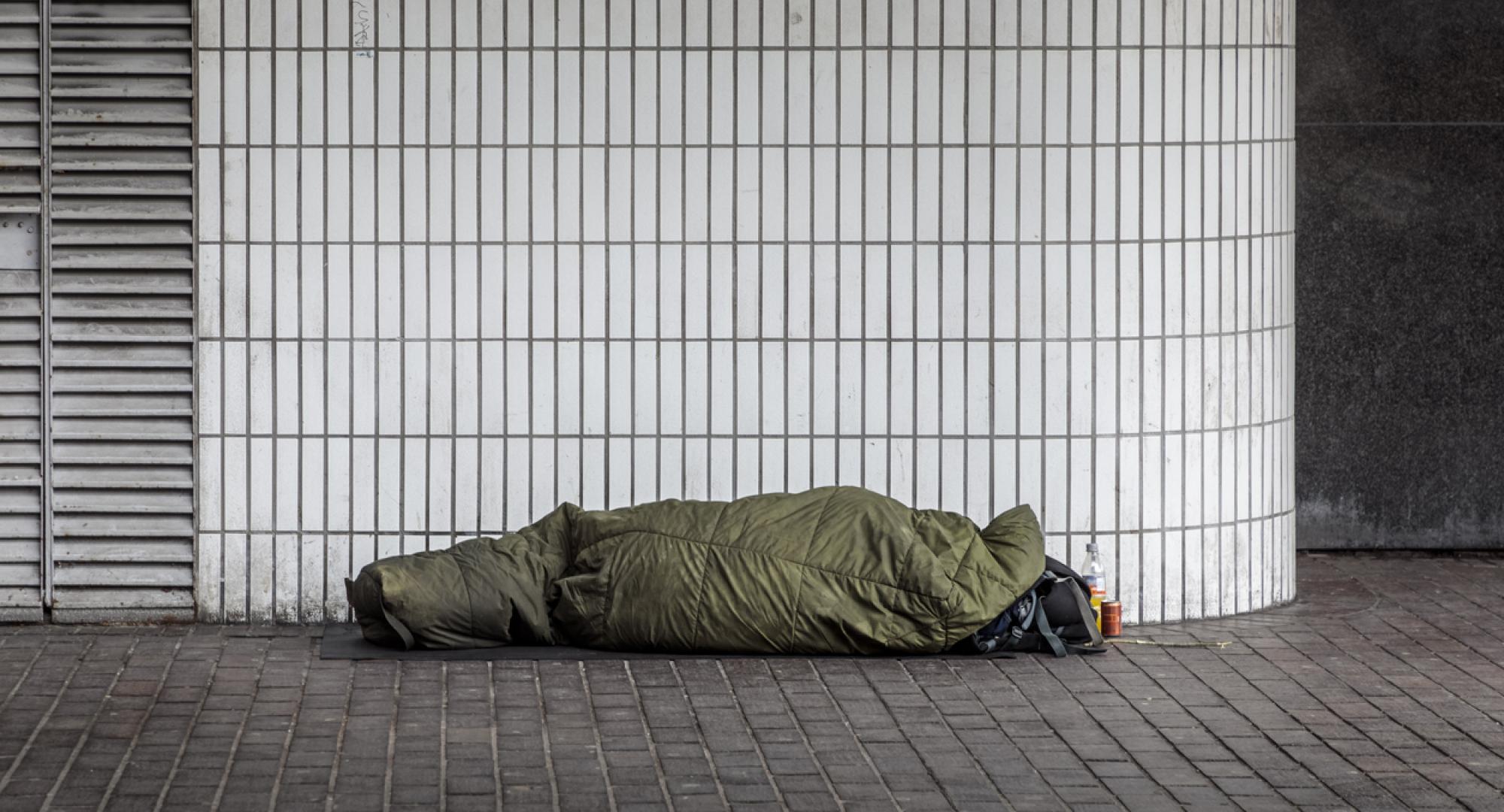A homeless man in a sleeping bag outside Euston Station, London