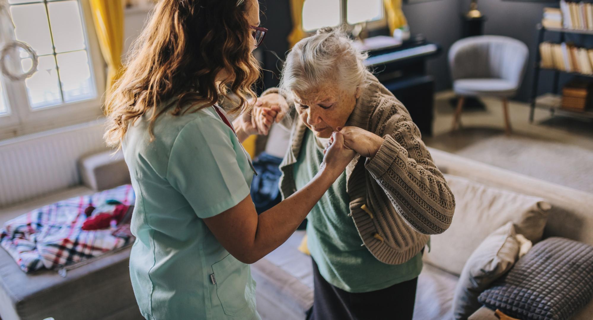 A nurse visits an elderly disabled woman at home