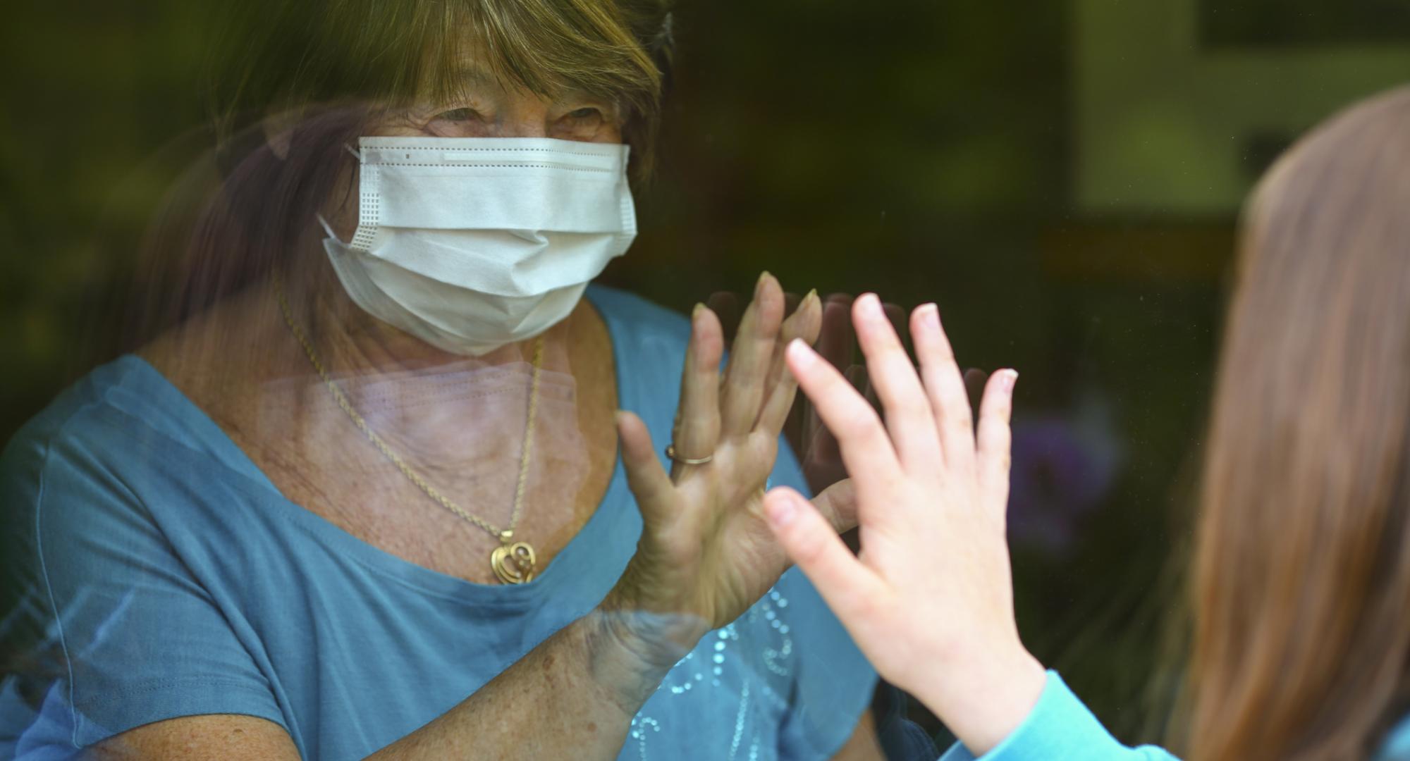 Elderly woman being visited by family during a pandemic