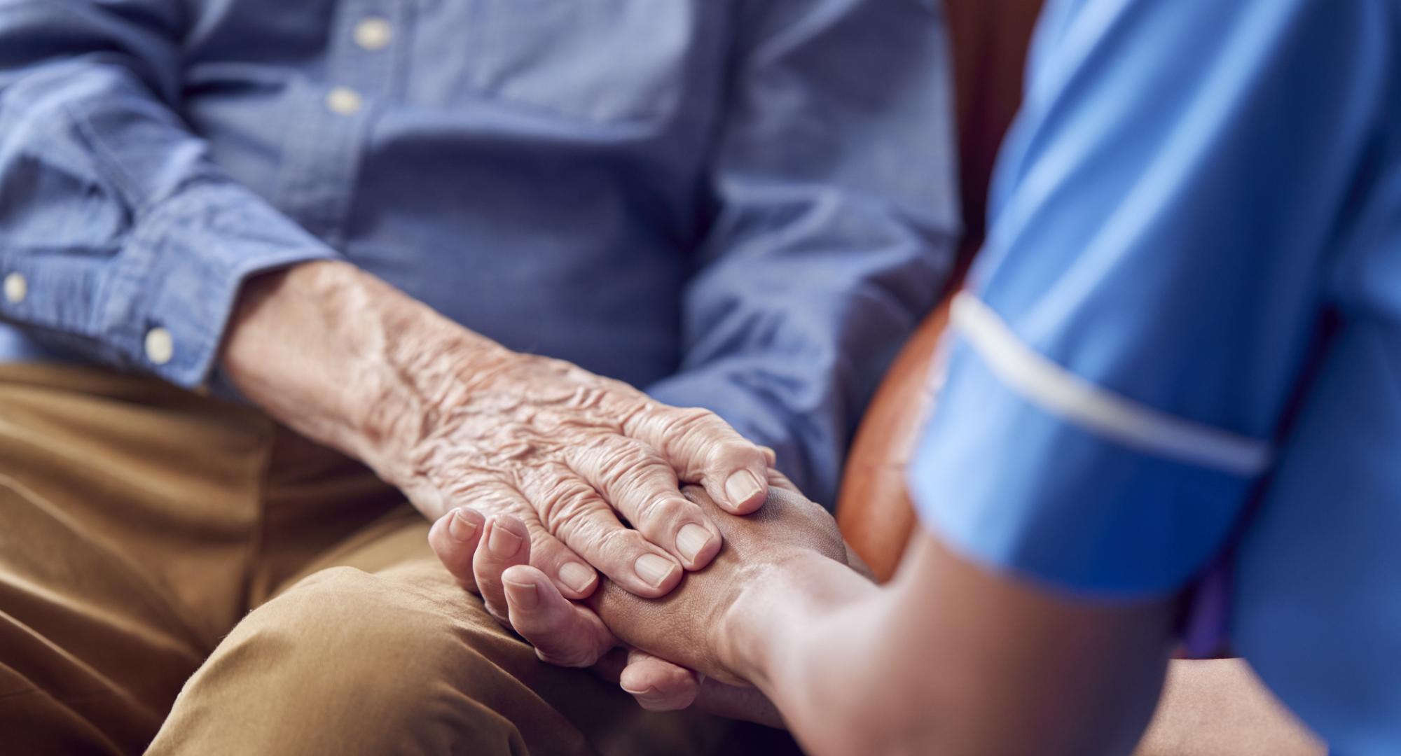 Nurse holding mans hand