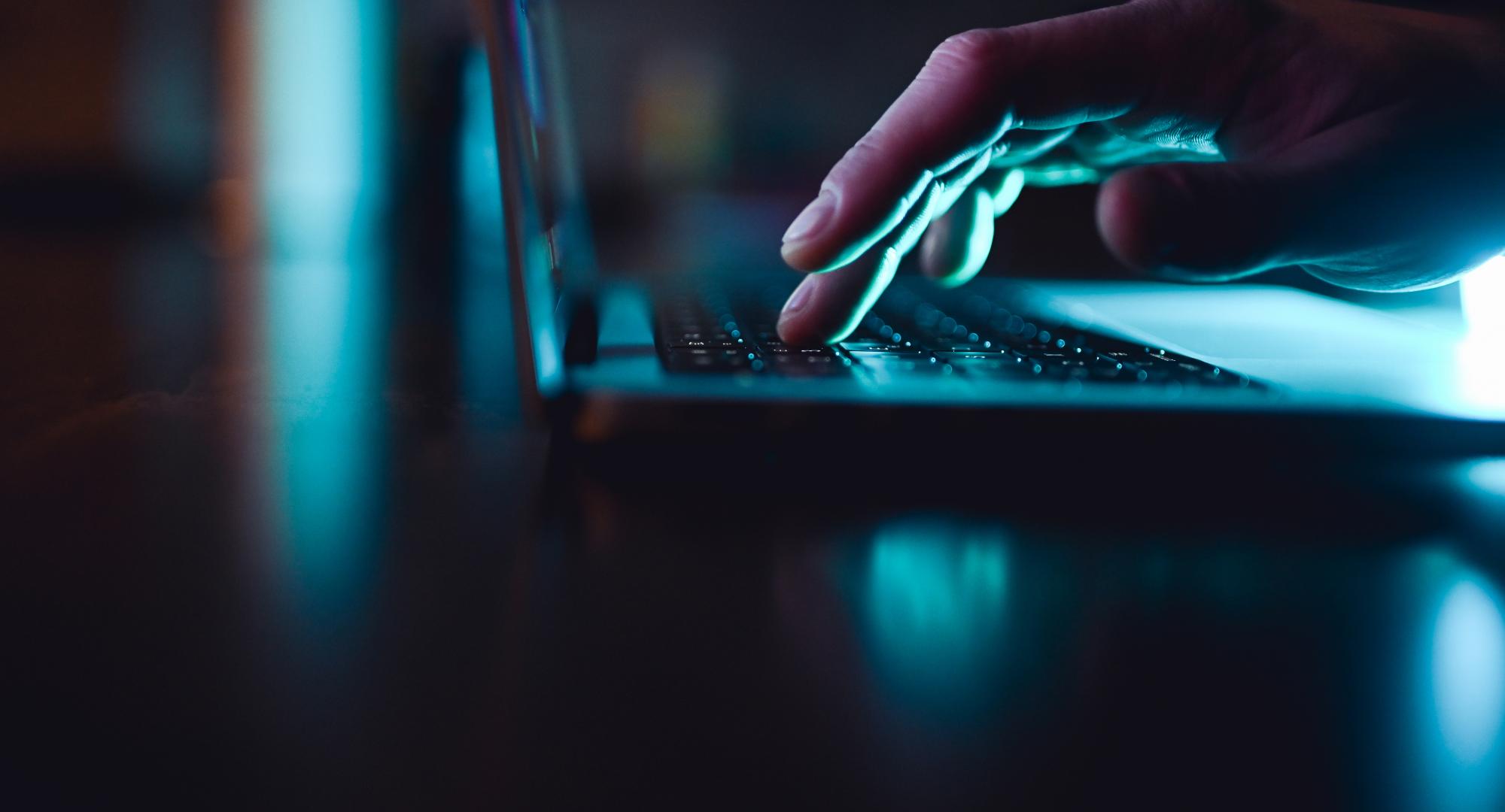Hand using a laptop keyboard