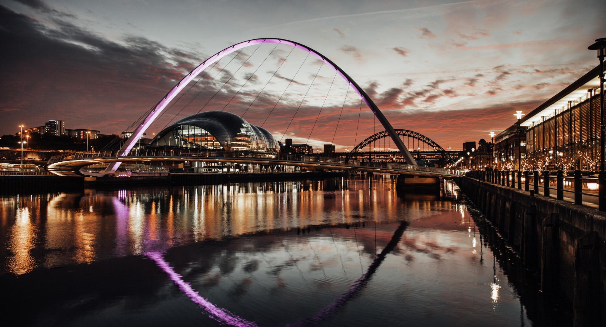 Millennium bridge at sunset with the Tyne Bridge in the background