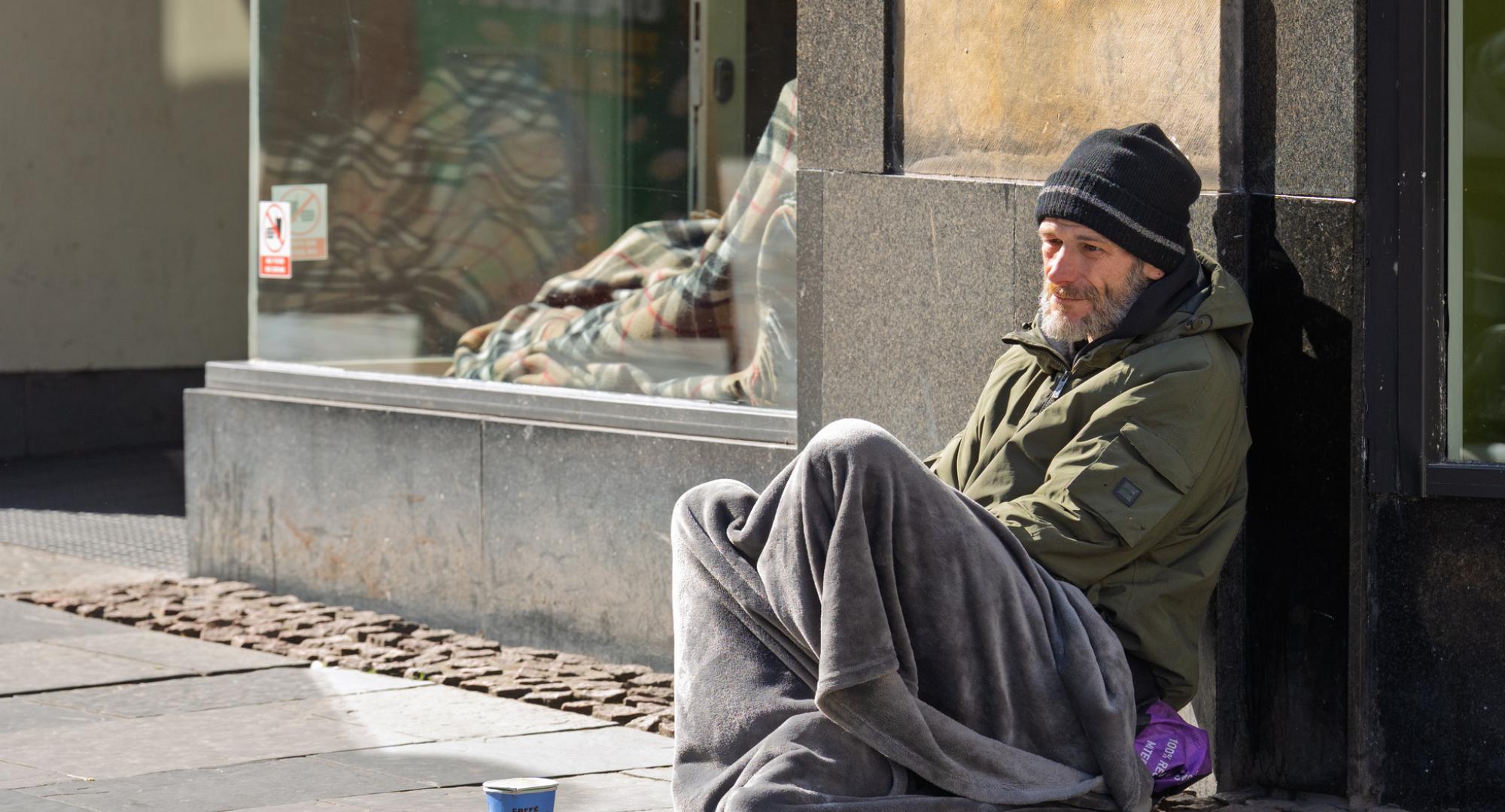 A homeless man sitting on the streets