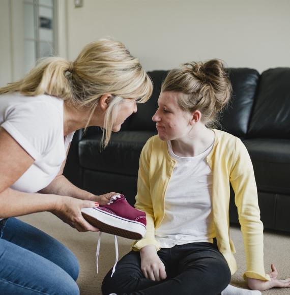 Carer helping girl with her shoes 