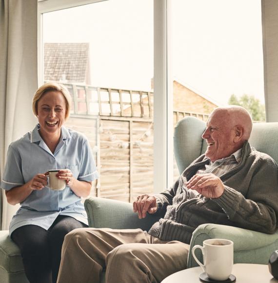 carer nurse laughing with older gentleman