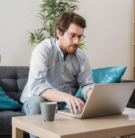 Man sits at computer, working from home.