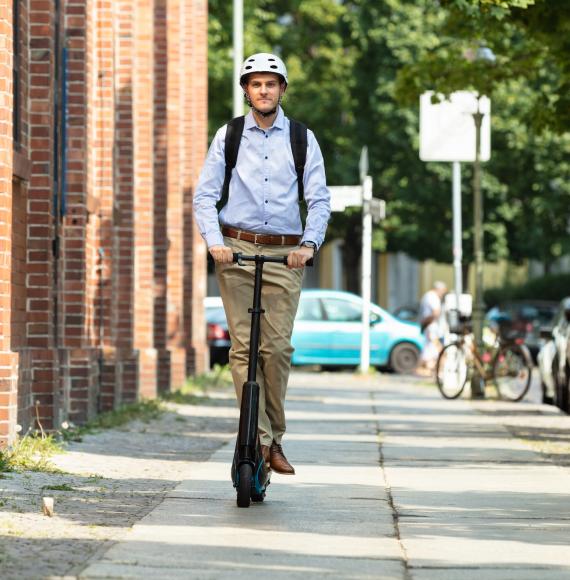 Man rides e-scooter through town