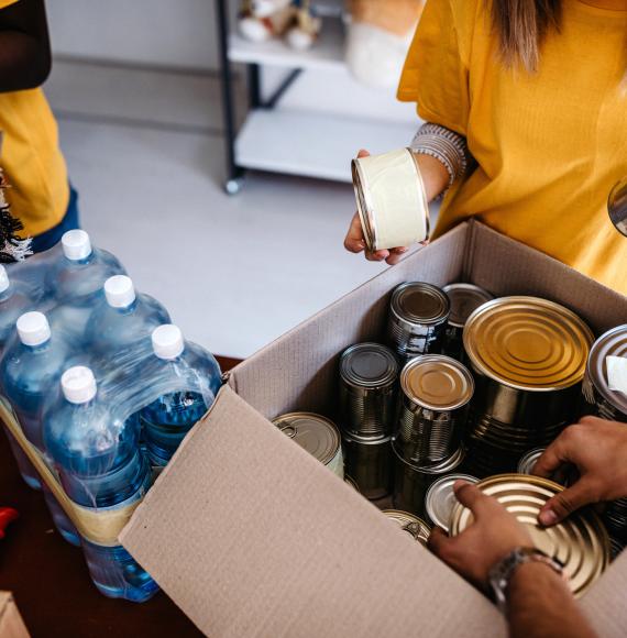 Food bank volunteers pack a box of food.