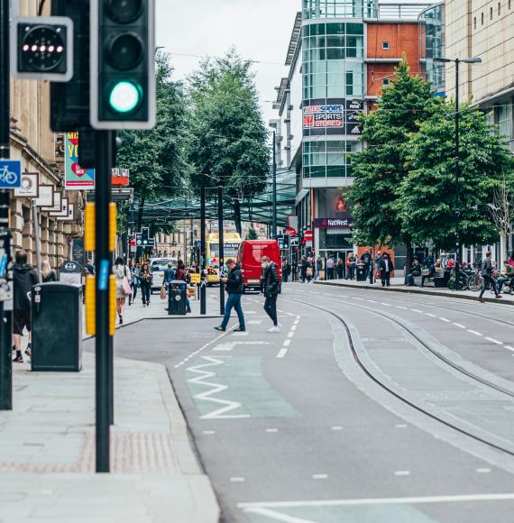 Busy Manchester street with pedestrians on the pavement.