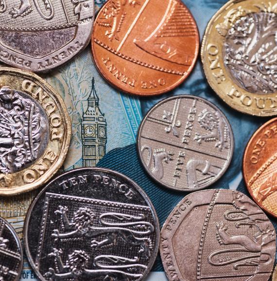 Coins placed over a five pound note revealing the Elizabeth Tower.