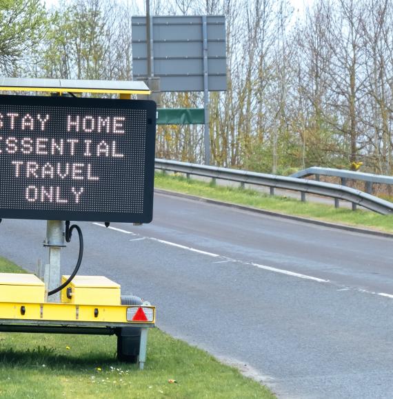 Sign tells motorists to stay at home, essential journeys only. 
