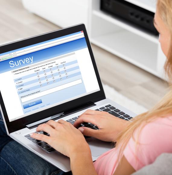Woman fills in online survey on her laptop. 