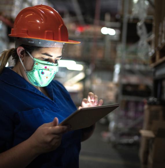 Girl in warehouse working on a tablet.